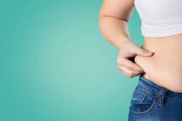 Image of woman pinching her love handles to show weight gain City of London